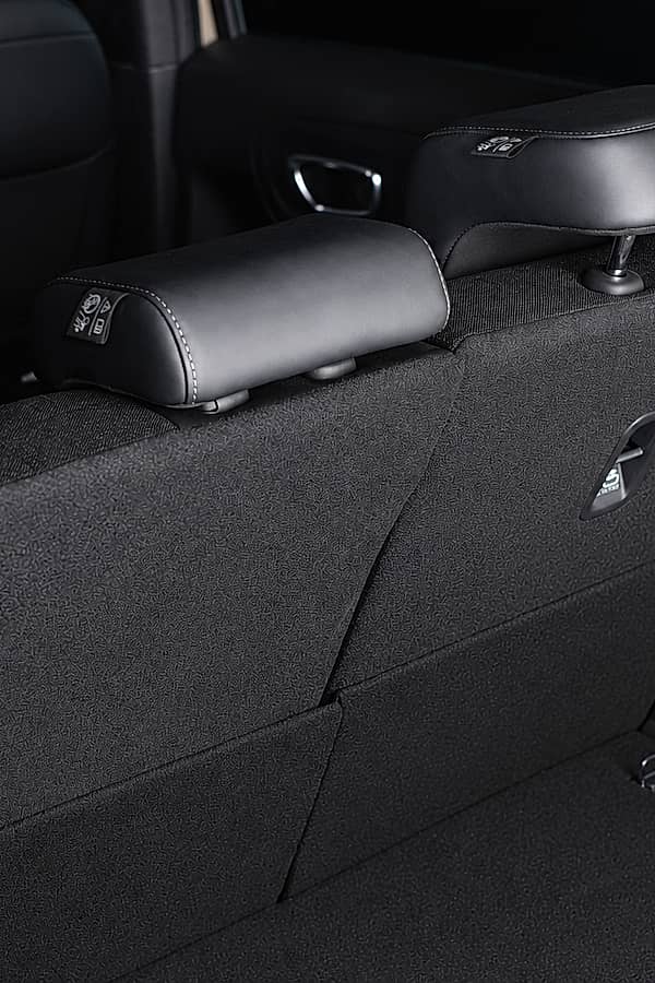 Close-up view of the back seats of Honda HRV, showing three adjustable headrests and folded down rear seats in a car trunk.