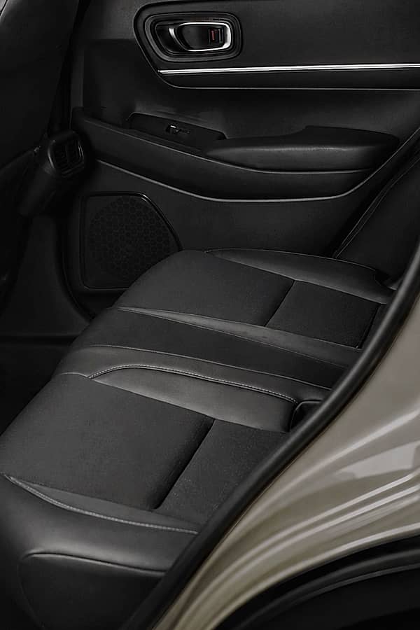 Rear seats of Honda HRV, showing black upholstery and a black door panel with a chrome handle.