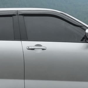 Silver Toyota Raize with black trim parked in a grassy, mountainous landscape.