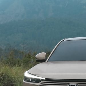 Honda HR-V parked on a dirt road with lush green grass and mountains in the background.